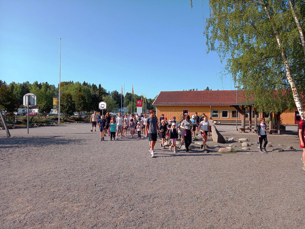 En grupp med barn och vuxna som går på en skolgård.