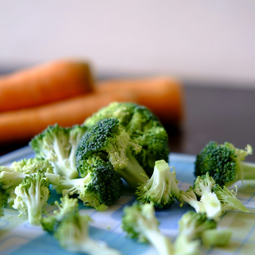 Broccoli och morötter på en skärbräda.